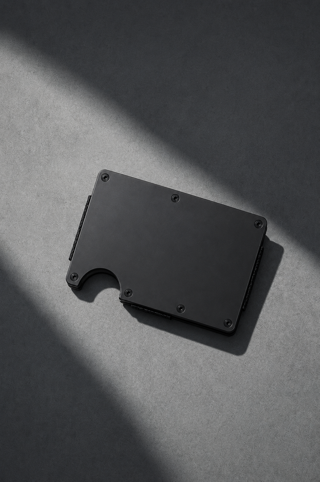 Slimfolio Slimline wallet, black satin finish, on a concrete surface